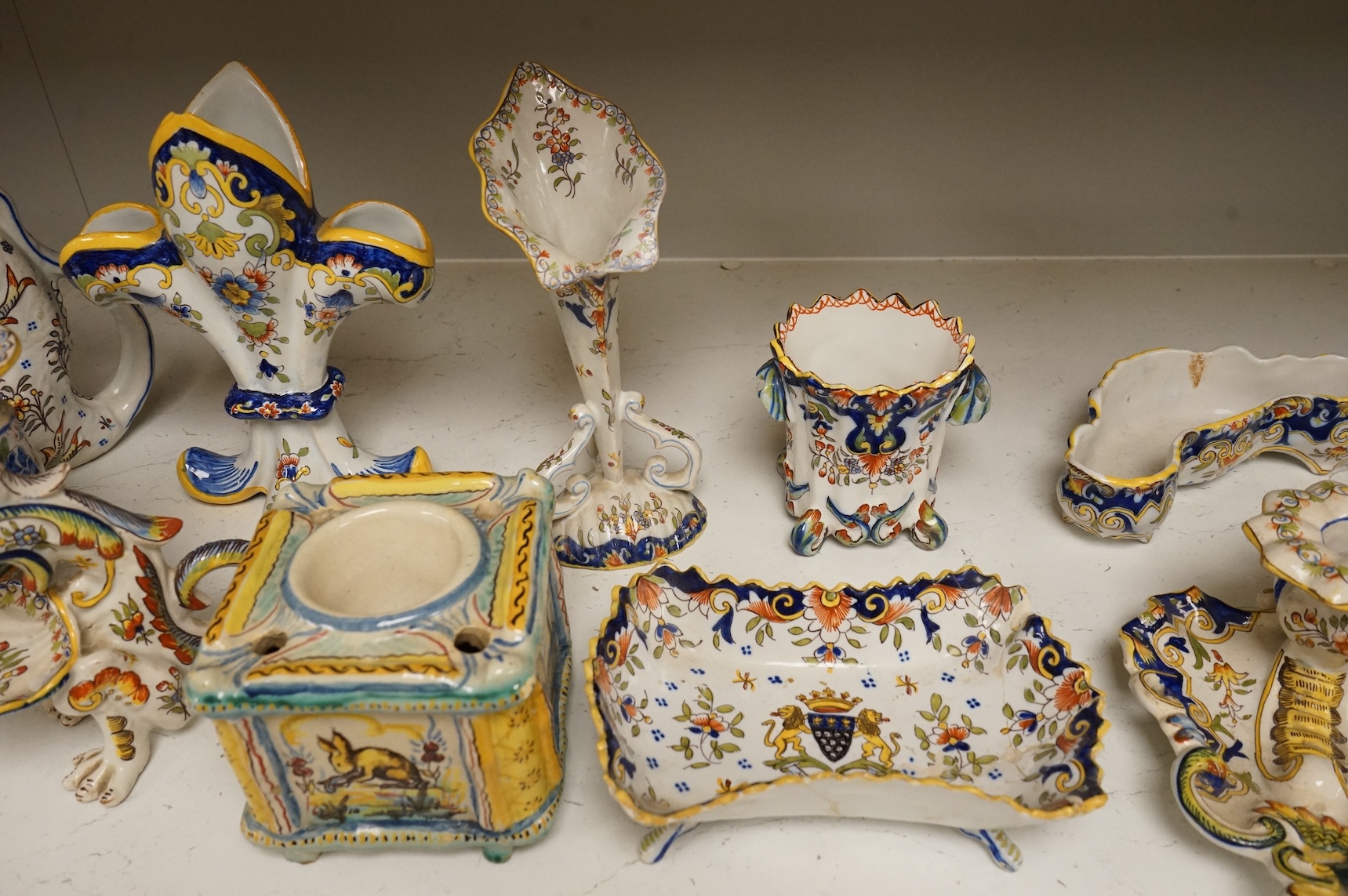 A group of French faience pottery to include spill vases, an ink well and dishes, largest 21cm high